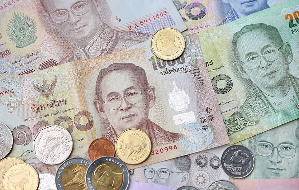 Thai Baht banknotes and coins in different denominations used for holiday travel in Thailand
