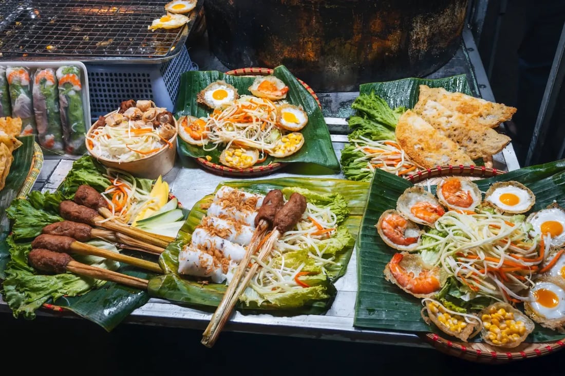 Vietnamese street food spread with grilled meats, fresh herbs, and noodles