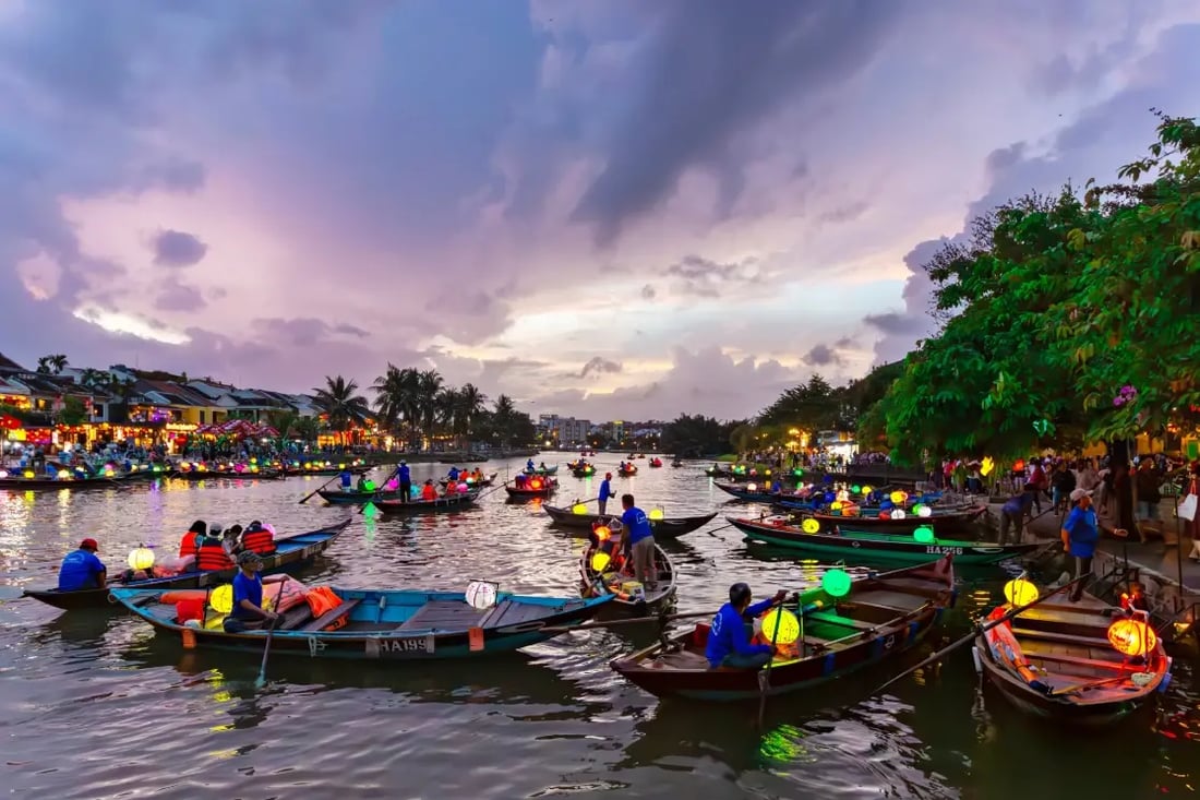 Boats on a river at sunset in Hoi An with lanterns and evening sky