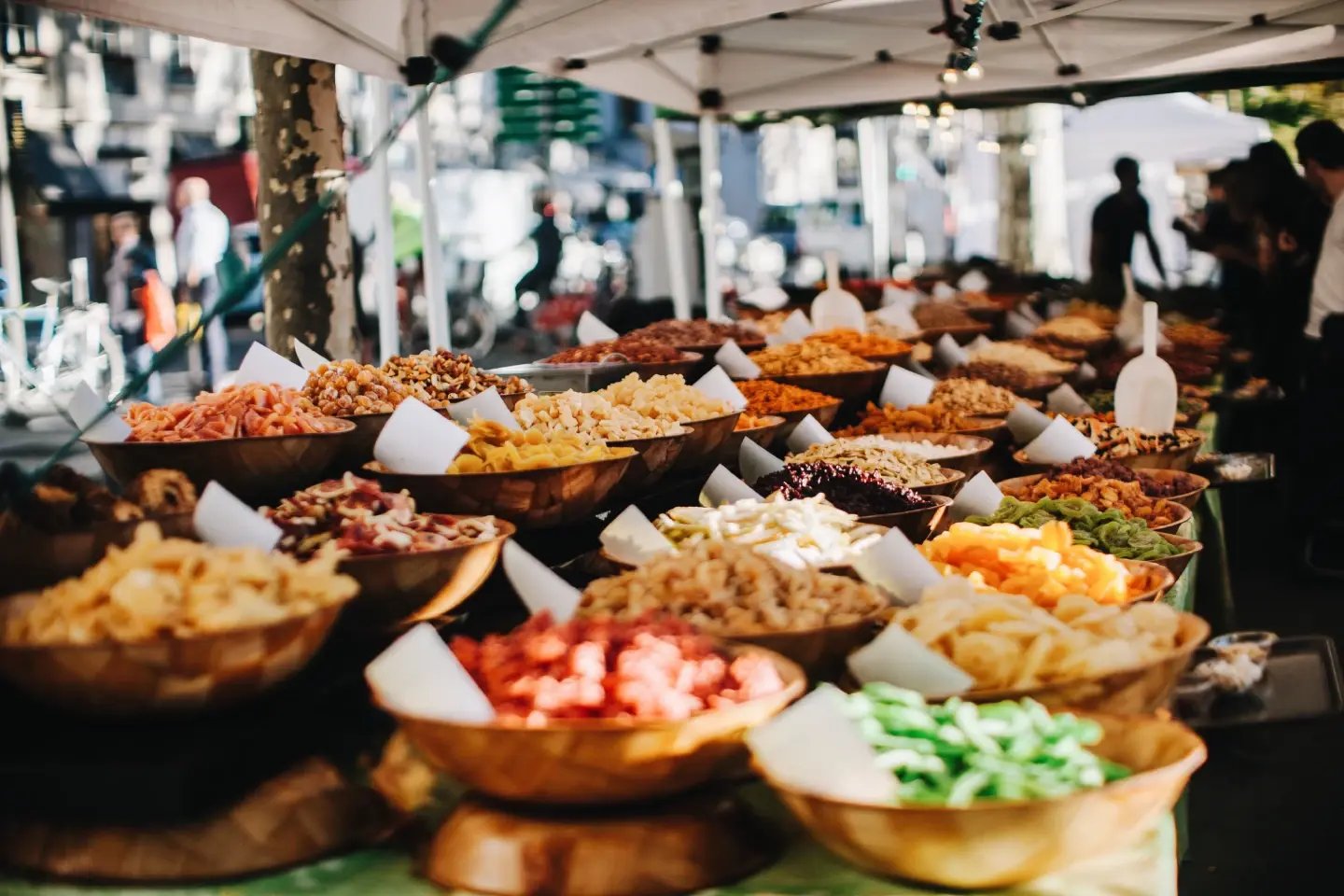Plates of Nepali dal bhat and side dishes laid out at a market food stall.