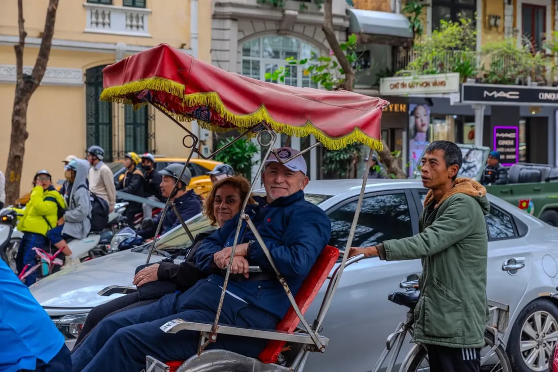 Cyclo ride through a busy Vietnamese street with driver and passengers