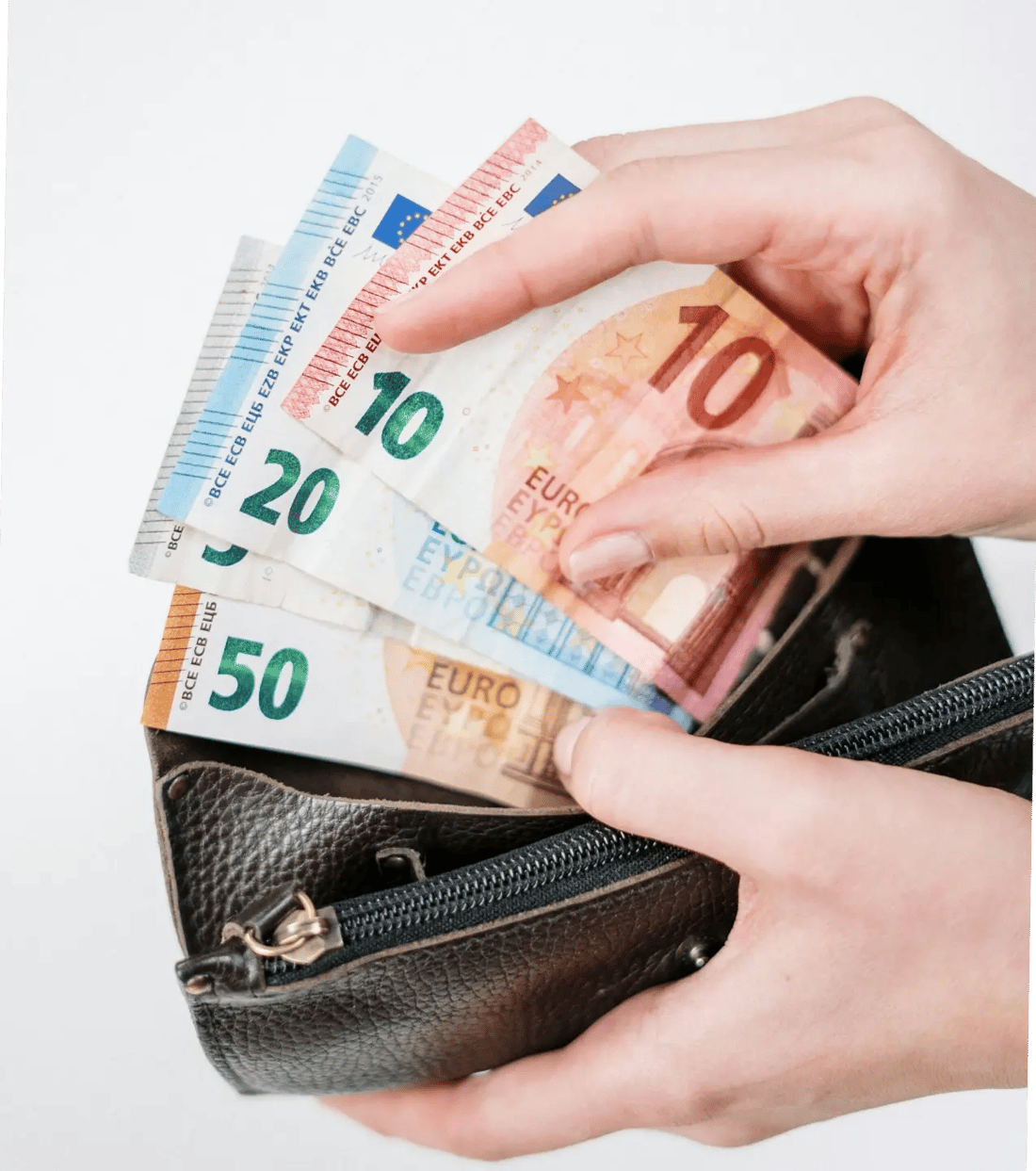 Traveller placing euro banknotes into a leather wallet, preparing spending money before a Paris trip.