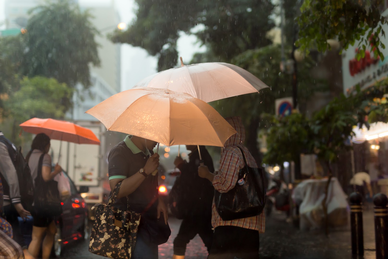 Pedestrians with umbrellas walking a rainy Taiwanese street
