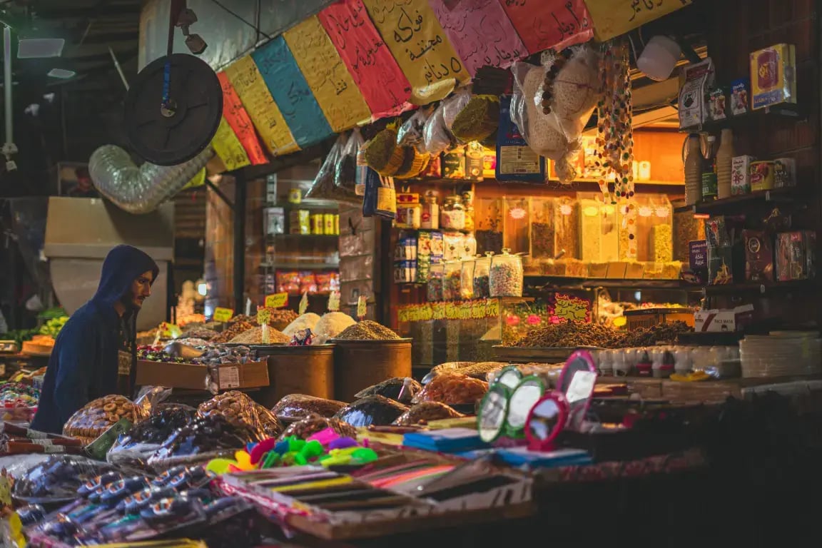 Spice and nut stalls piled high in a bustling Amman souk, Jordan