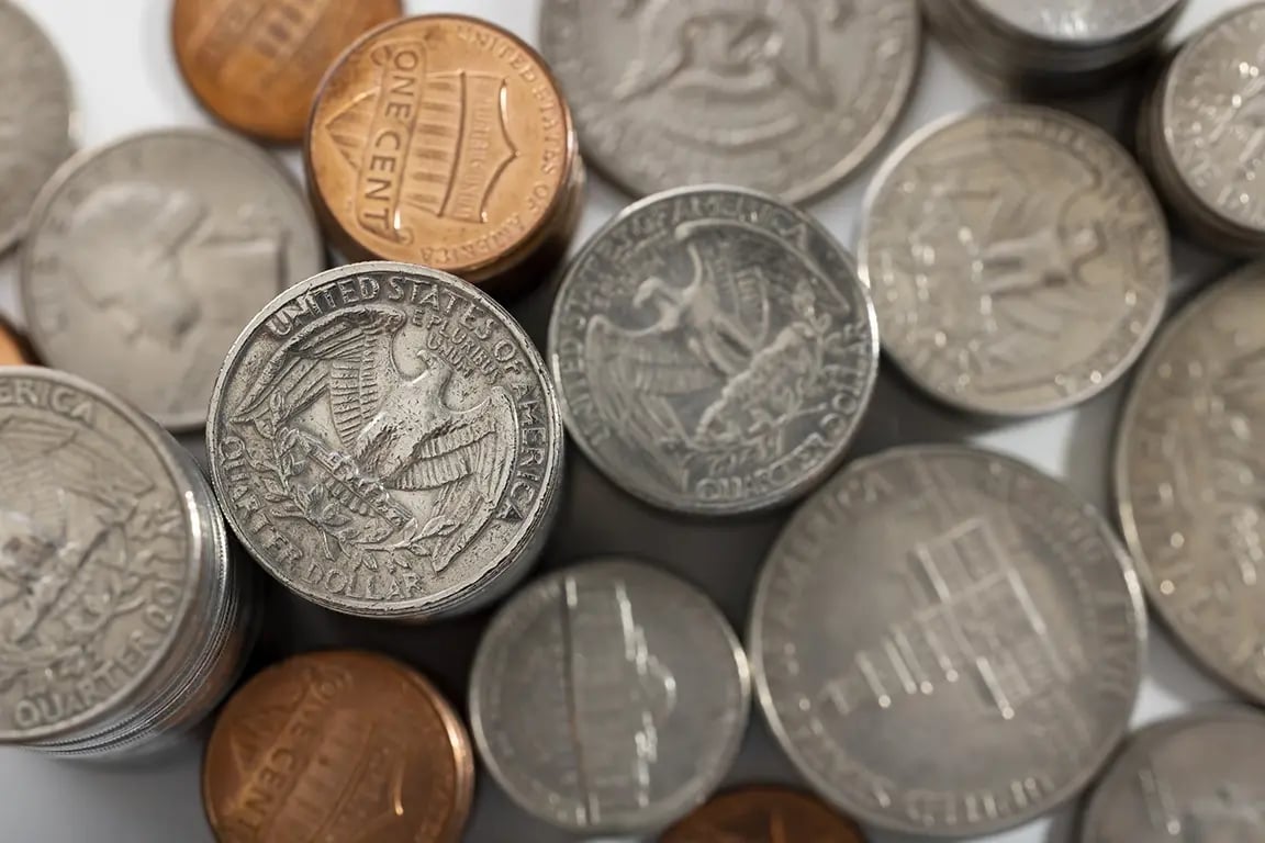 Close-up of US coins including quarters, dimes, and pennies.