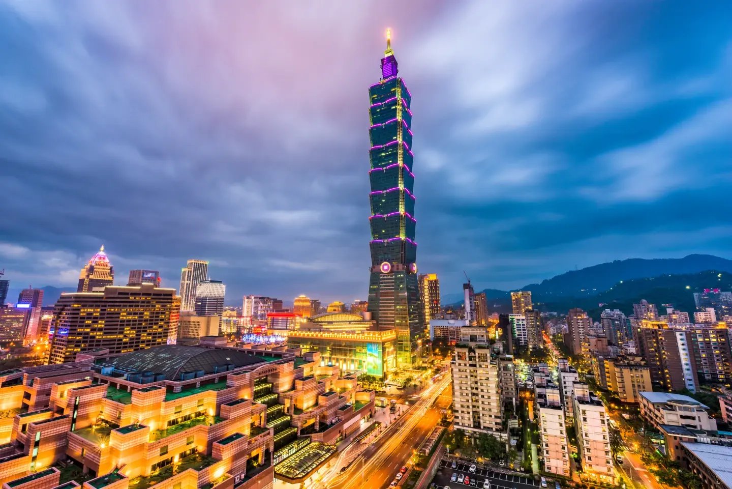 Taipei 101 lit up after dark against the Taiwan city skyline