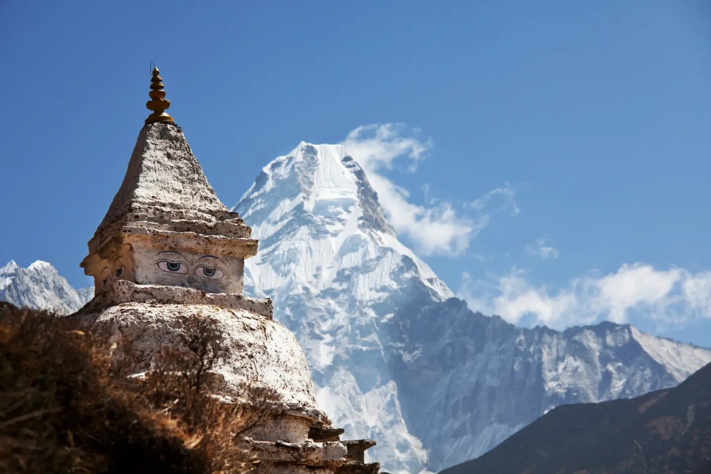 A Buddhist chorten with a snow-capped Himalayan peak rising behind it, Everest region, Nepal.