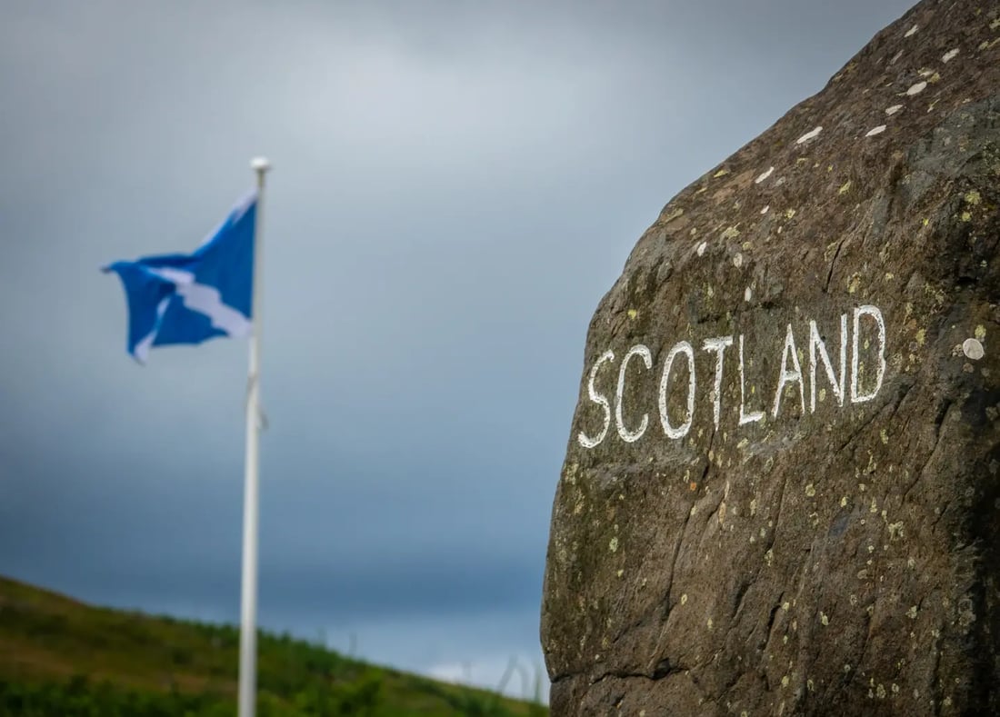 Scotland-England border sign with Scottish flag