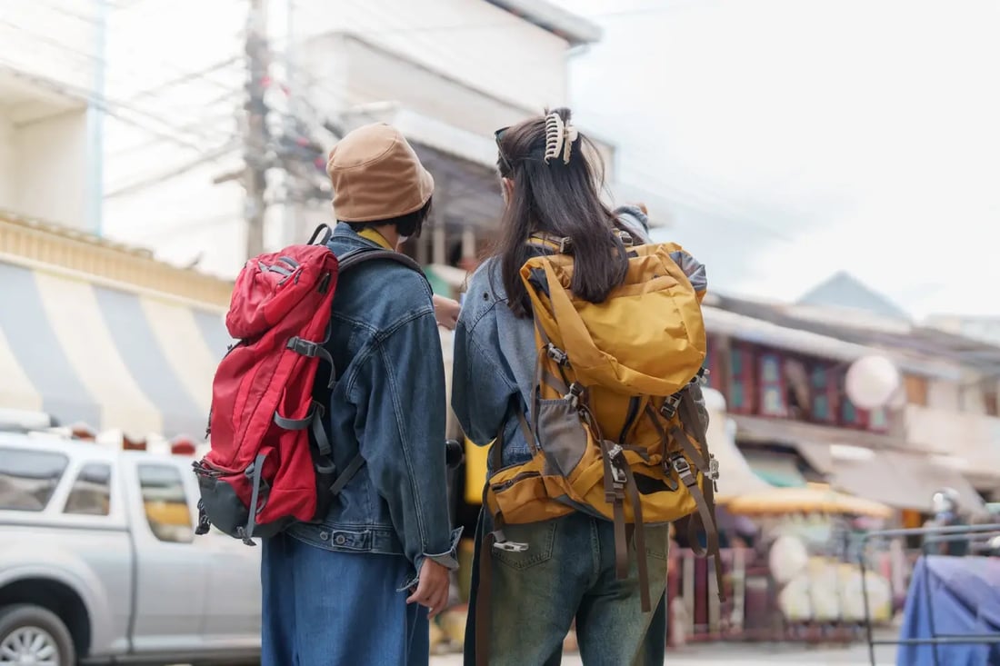 Backpackers walking through a busy market in Southeast Asia