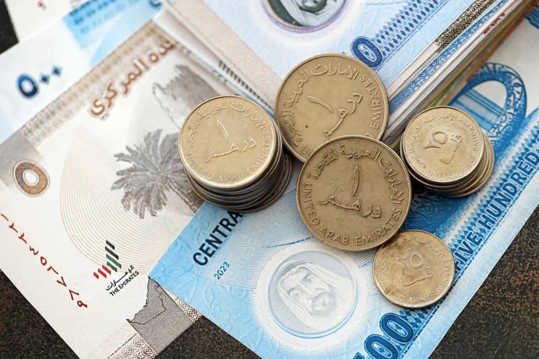 UAE dirham coins on top of dirham banknotes in mixed denominations