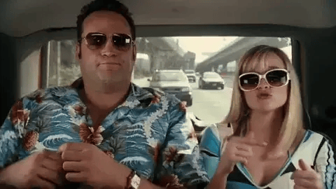 Man and woman in sunglasses riding in a car, relaxed and playful during a travel scene in Spring Breakers.