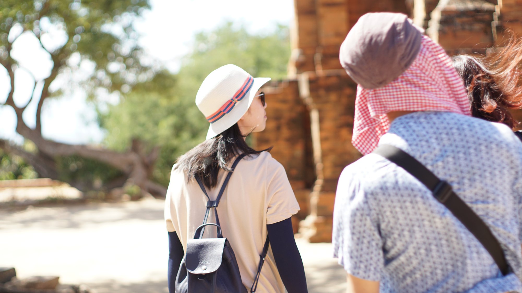 Two travellers in hats exploring sandstone heritage sites in AlUla