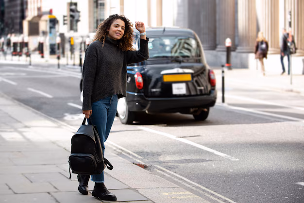 Woman hailing a London black cab while carrying a backpack